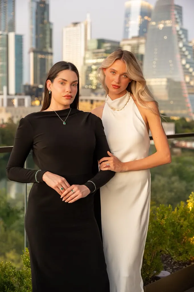 Two models wearing fine jewelry on a rooftop with the Austin skyline