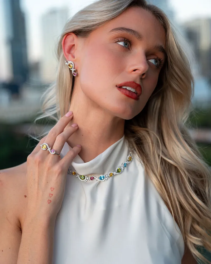 Model wearing diamond and gemstone rings with a colorful necklace in Austin, Eterna Jewels