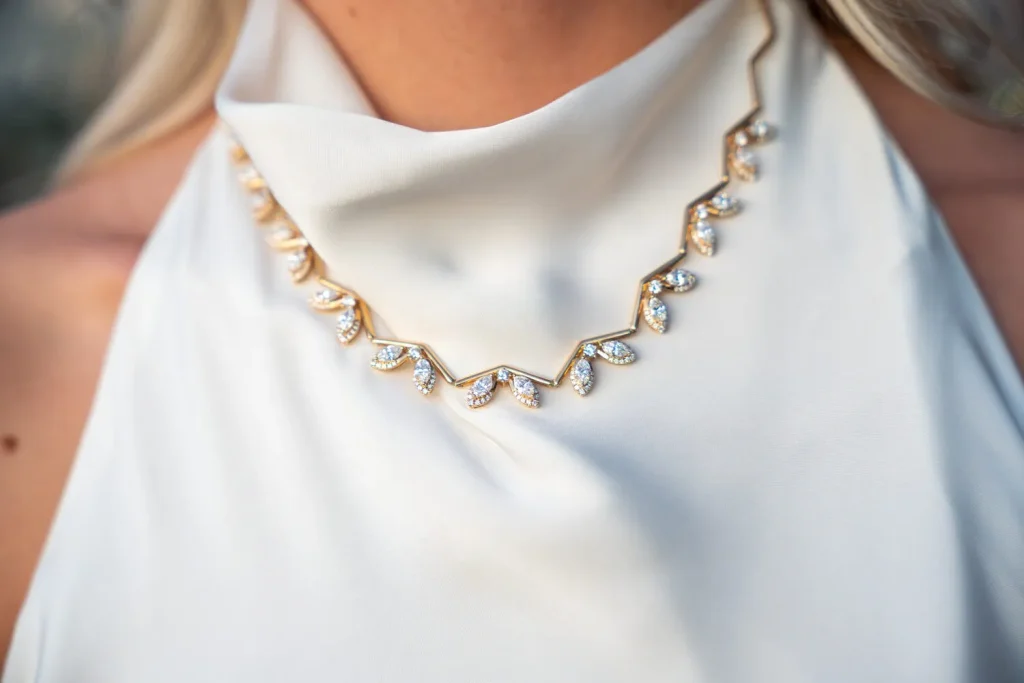 Yellow gold diamond wave necklace worn with a white halter dress, Eterna Jewels Austin